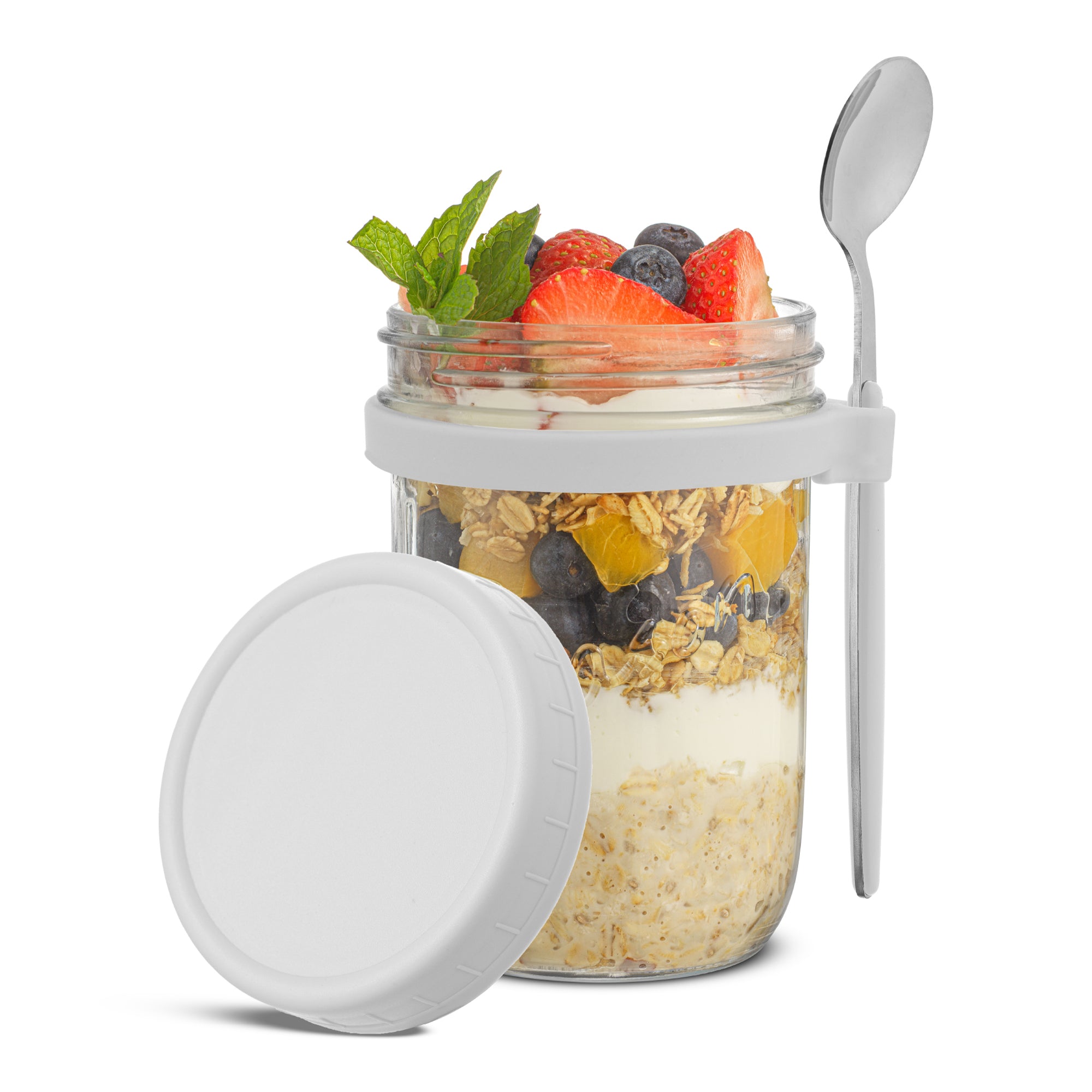 JoyJolt white overnight oats container and spoon filled with fruit, granola, and yogurt.