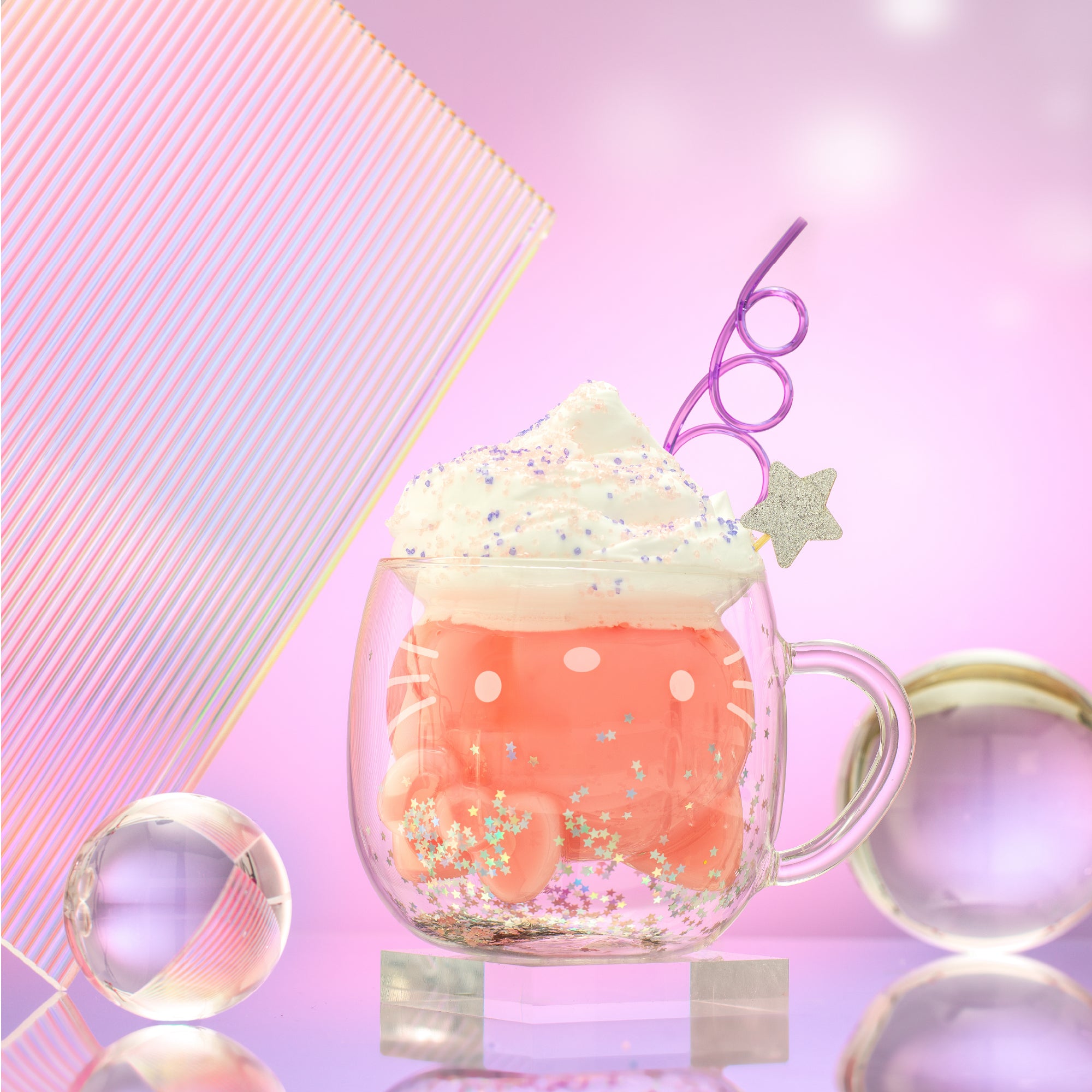 A 3D double wall Hello Kitty mug filled with a pink drink and whipped cream. Decorated with sprinkles and a swirly straw.