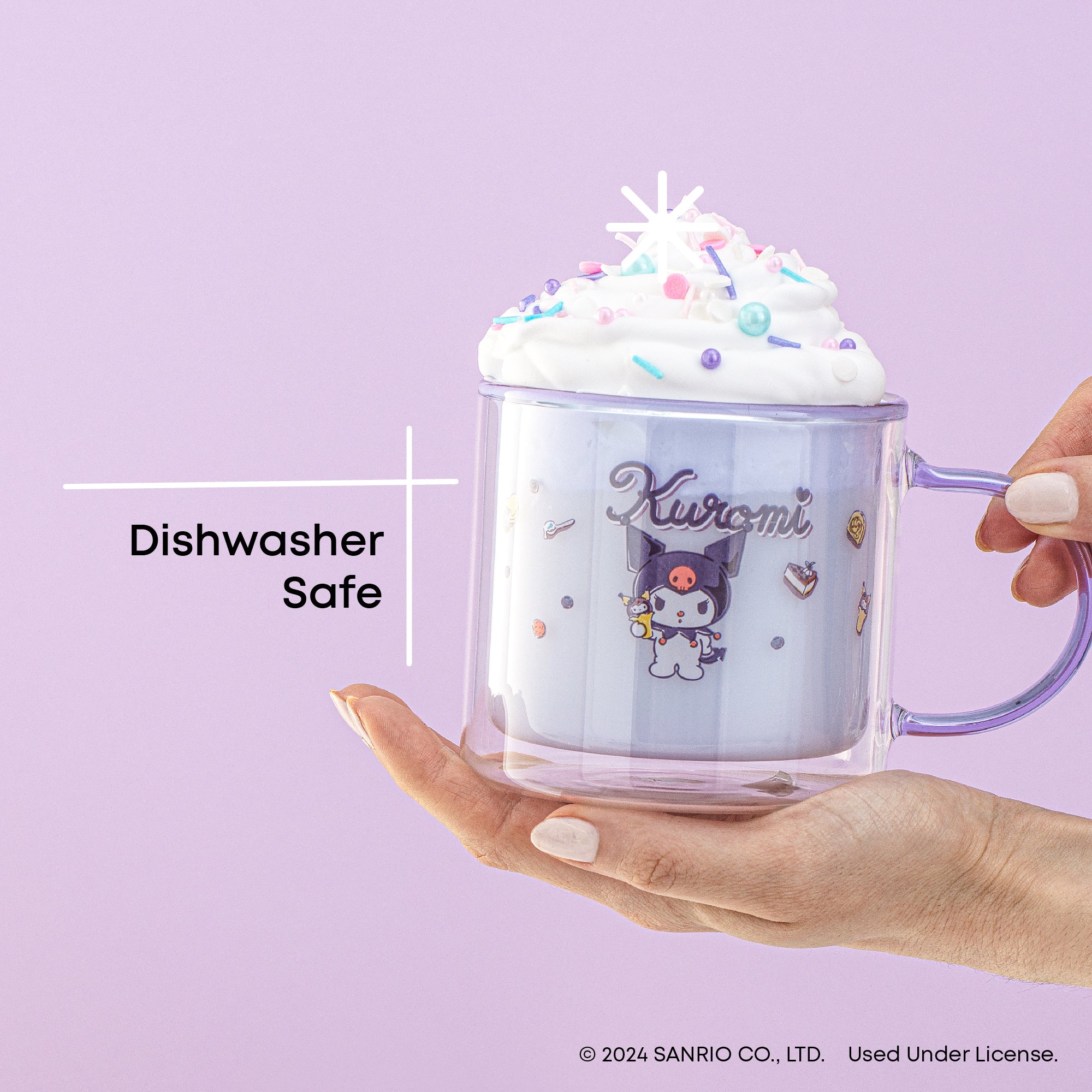 A person holding a clear glass mug with a Kuromi graphic and logo. The mug has whipped cream. Text on the image reads, "Dishwasher Safe." 