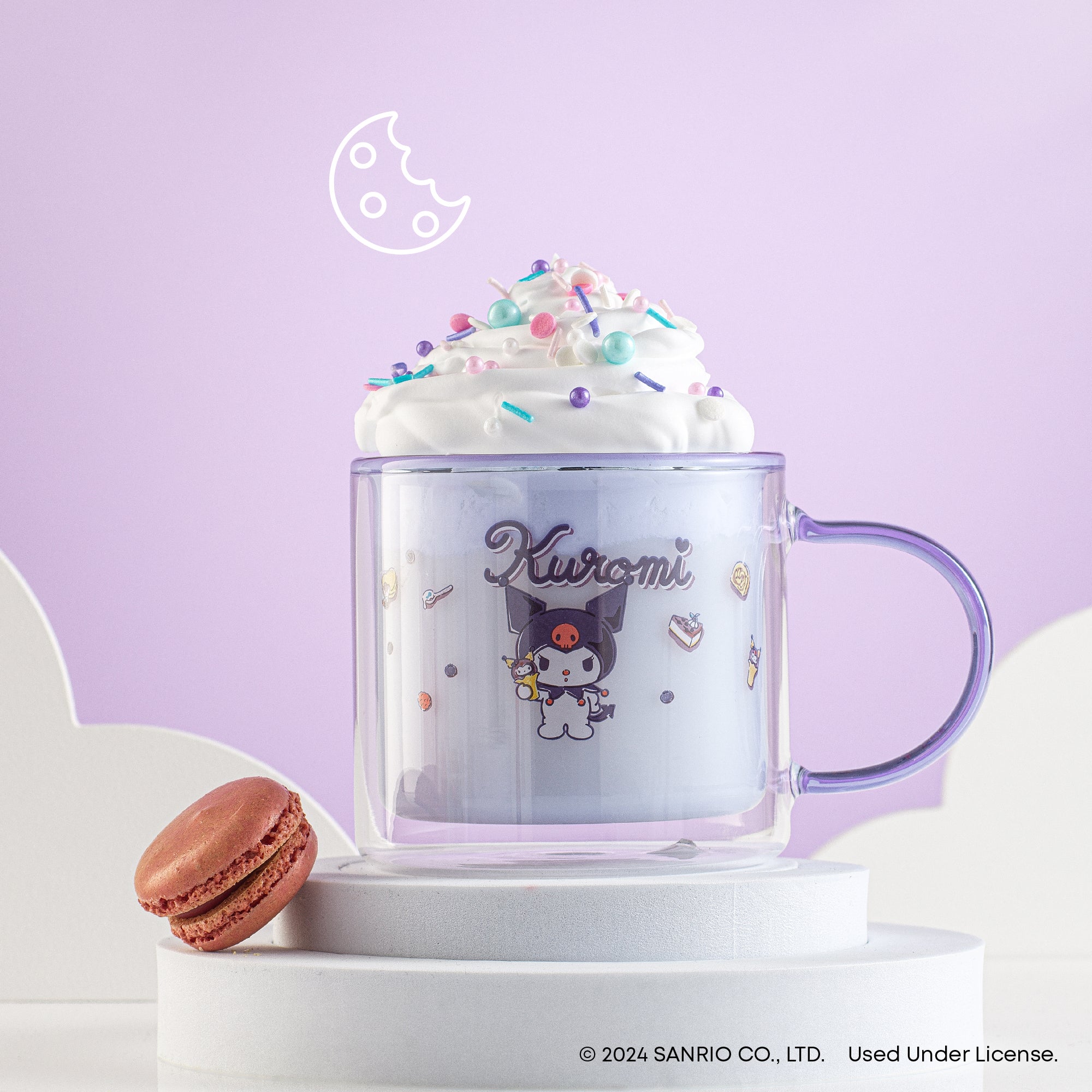 A JoyJolt purple clear glass mug with a creamy drink topped with whipped cream and a picture of Kuromi, a character from Hello Kitty. 