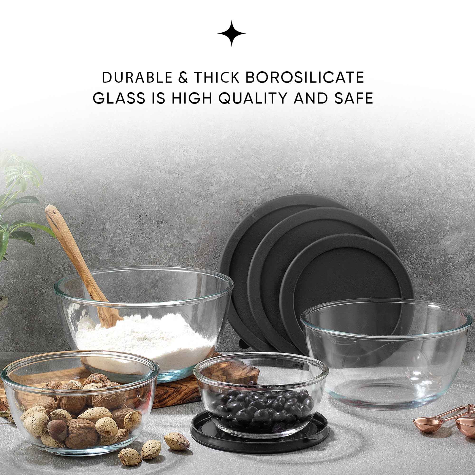A set of four glass bowls with black lids on a table. The text  says  “DURABLE & THICK BOROSILICATE GLASS IS HIGH QUALITY AND SAFE”.